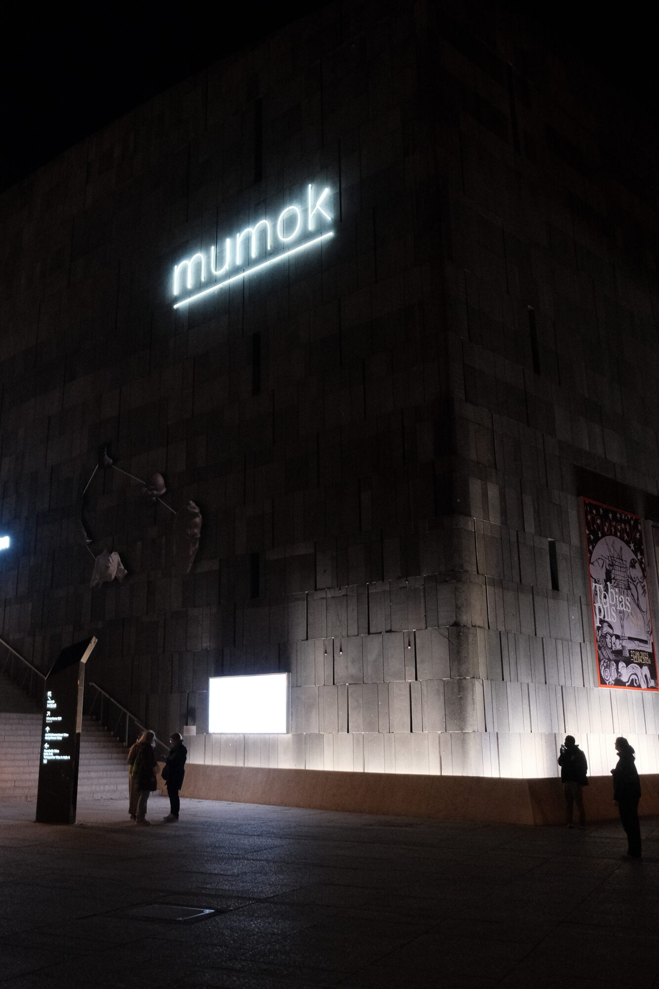 nighttime shot of the cuboid Museum of Modern Art looming out of the dark; very drama