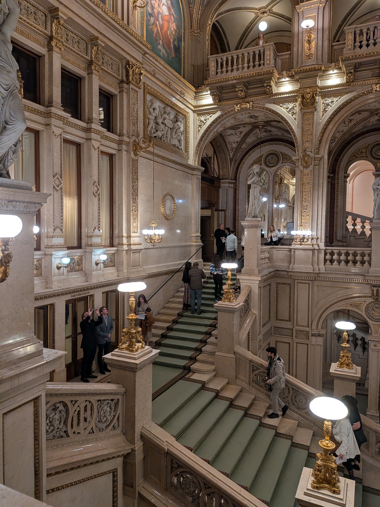 off-angle shot of the Staatsoper interior, slightly better visibility of the statues along the stairs