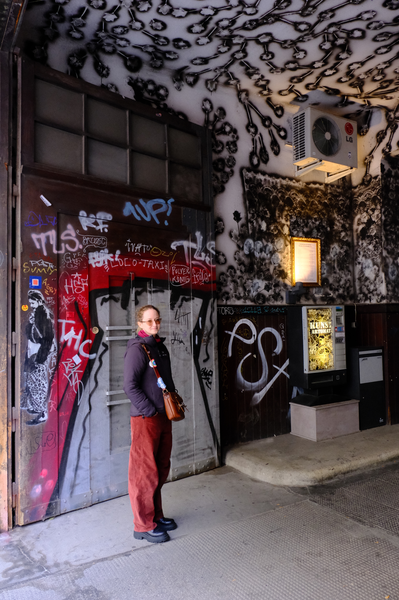 image of my partner in the entry arch to Westlicht, which has much graffiti